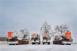 A line up of Liebherr wheeled mobile telescopic cranes in white and orange BKL colours in the snow