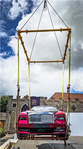 Red Rolls Royce suspended in the air using a Modulift CMOD spreader frame on a Southern Cranes and Access wheeled mobile telescopic crane