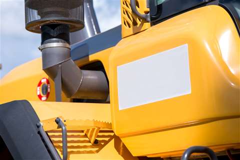 Side of yellow excavator with an exhaust pipe protruding from it.